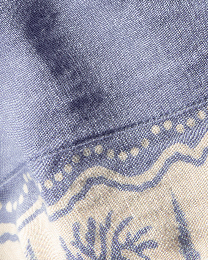 Close-up of the LSPACE April Top in shell, highlighting the cream embroidered trim detail against the periwinkle blue fabric.