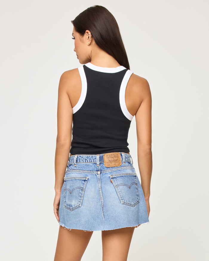 Back view of a model wearing the LSPACE Ash Tank in black white, revealing the racerback design with white contrast trim.