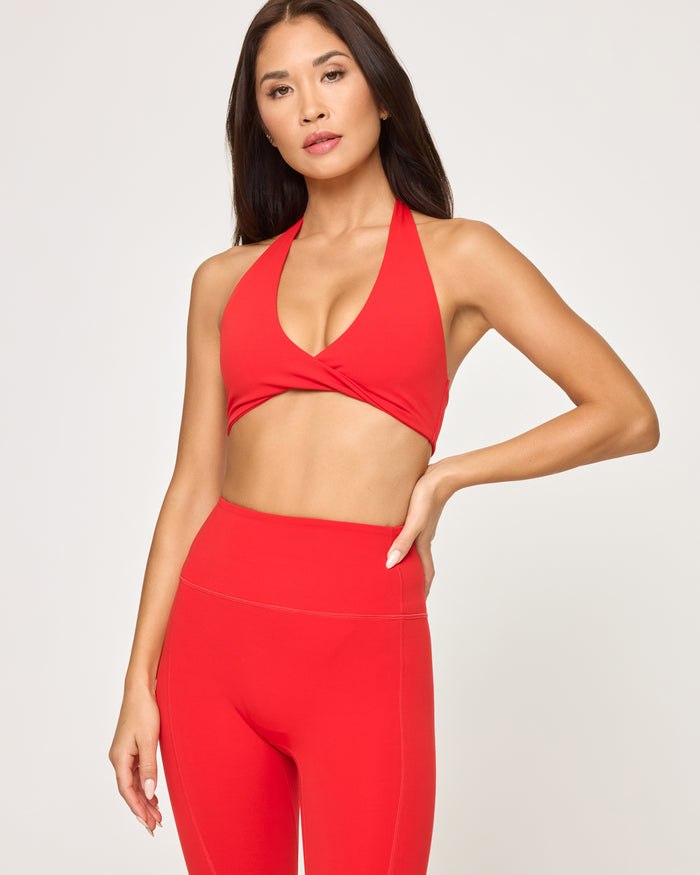 Close-up front view of model wearing the Level Up Legging in flame showing the waistband detail, with matching flame Jeanne Bra.