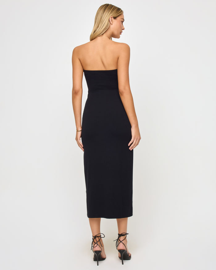 Back view of a model wearing the LSPACE Lisette Dress in black, showing the clean strapless back of the fitted midi dress.