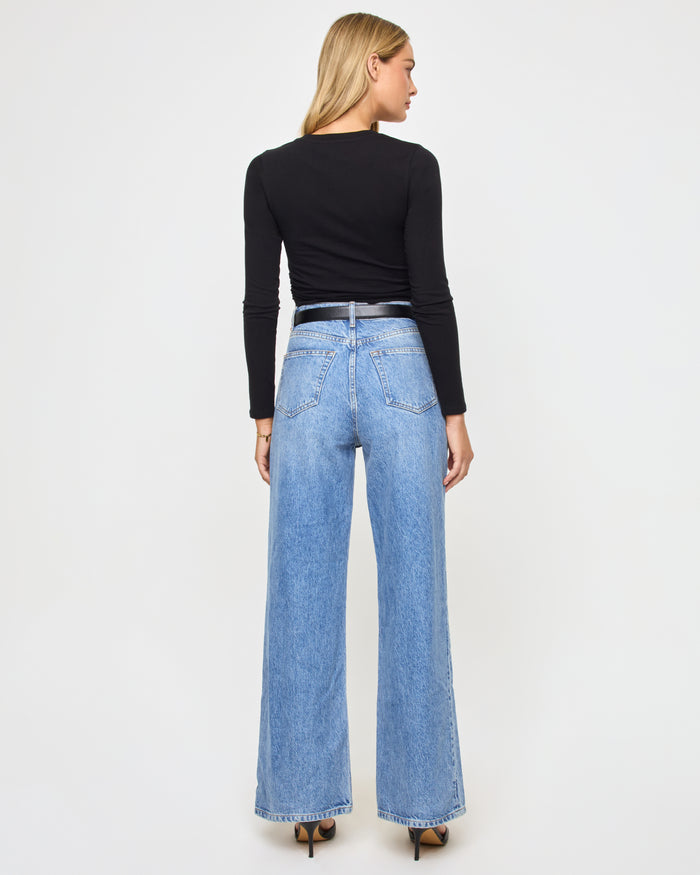 Back view of a model wearing the LSPACE Marseille Top in black, a long-sleeve cropped top with a smooth fitted back.