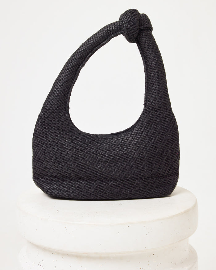 Side view of the Ryder Bag in black on a white pedestal.