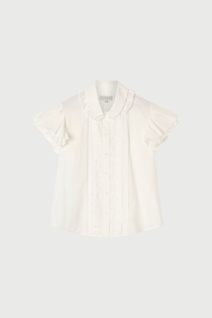 White blouse with ruffled sleeves on a light gray background