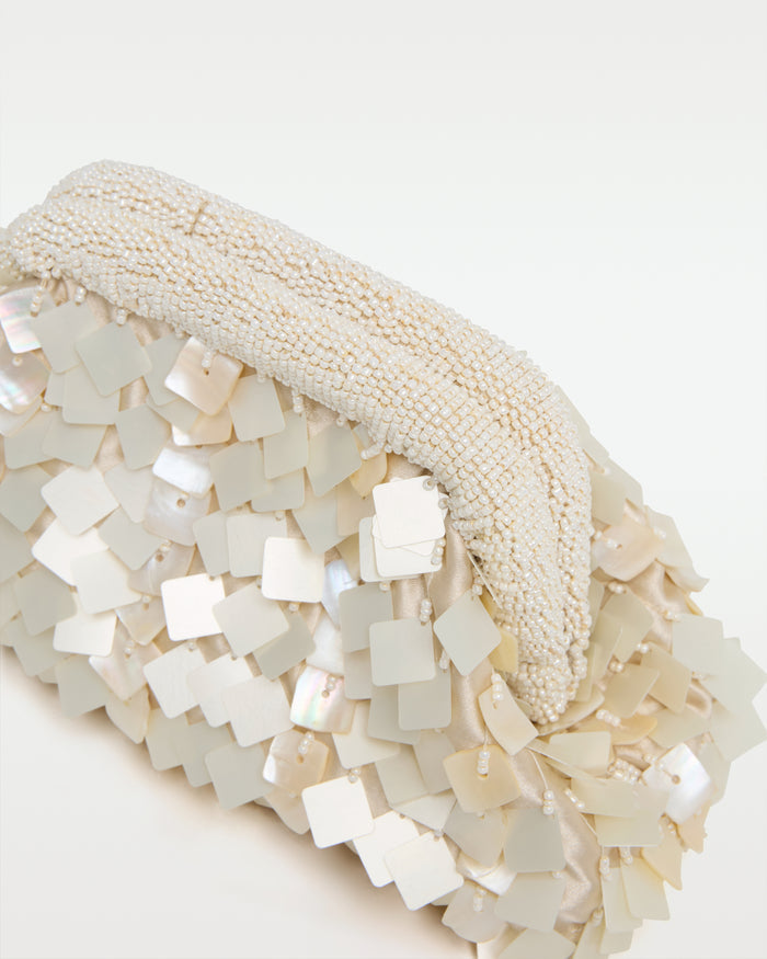 Close-up detail of the Vienna Clutch in cream showing the beaded frame clasp and the layered iridescent mother-of-pearl shell tile paillettes.