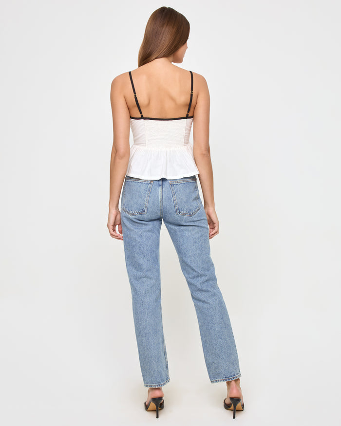 Back view of a model wearing the LSPACE Agnes Top in cream-black, showing the open back design with black adjustable straps.