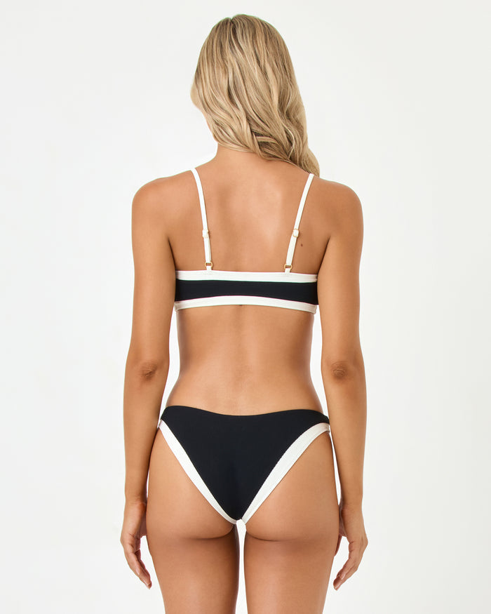 Back view of a model wearing the LSPACE black-cream Madison Bikini Top and Alex Bikini Bottom.