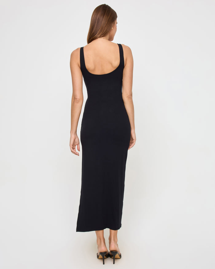 Back view of a model wearing the LSPACE Alexis Dress in black, showing the open scoop back and fitted ribbed silhouette.