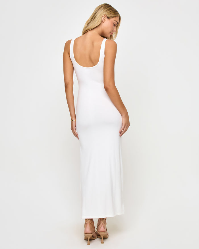 Back view of a model wearing the LSPACE Alexis Dress in cream, showing the open scoop back and fitted ribbed silhouette.