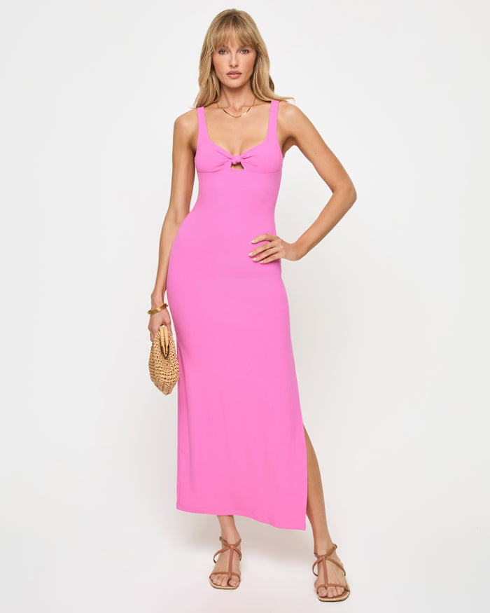 Front view of a model wearing the LSPACE Alexis Dress in Sweetheart, a bright pink fitted ribbed knit maxi dress with a sweetheart neckline, keyhole cutout, and side slit, on a neutral studio background.