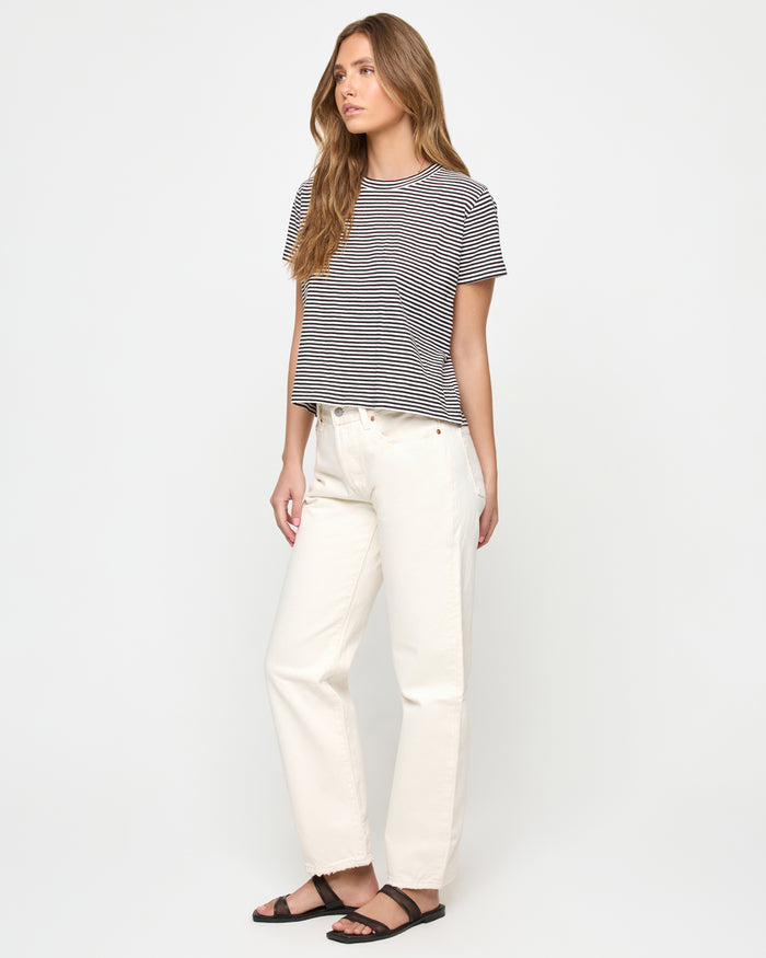 Three-quarter view of a model wearing the LSPACE All Day Top in black-cream, showing the relaxed cropped fit and horizontal stripe pattern.