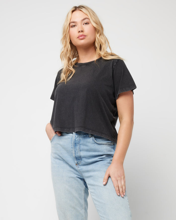 Front view of a model wearing the LSPACE All Day Top in black, styled with light wash jeans.