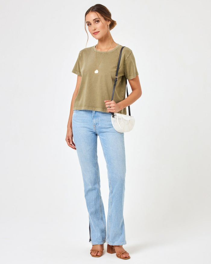 Full body front view of a model wearing the LSPACE All Day Top in olive branch, styled with light wash jeans and a white crossbody bag.