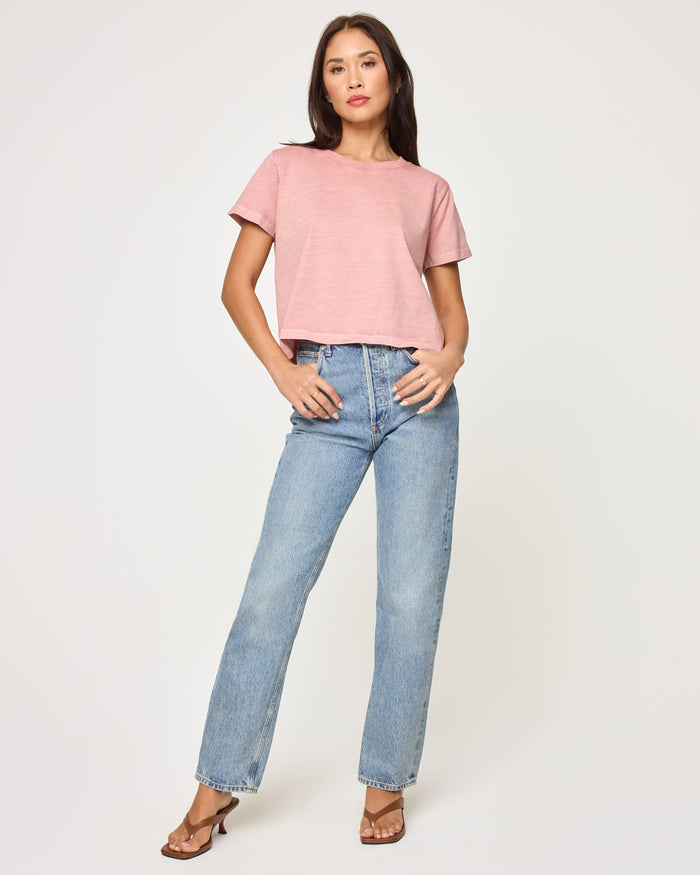 Front view of a model wearing the LSPACE All Day Top in pink clay, a relaxed cropped boxy t-shirt with a crew neckline and short sleeves, styled with wide-leg jeans.