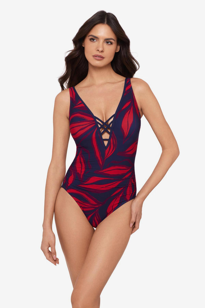 Woman wearing a red leaf printed one-piece swimsuit with an X front