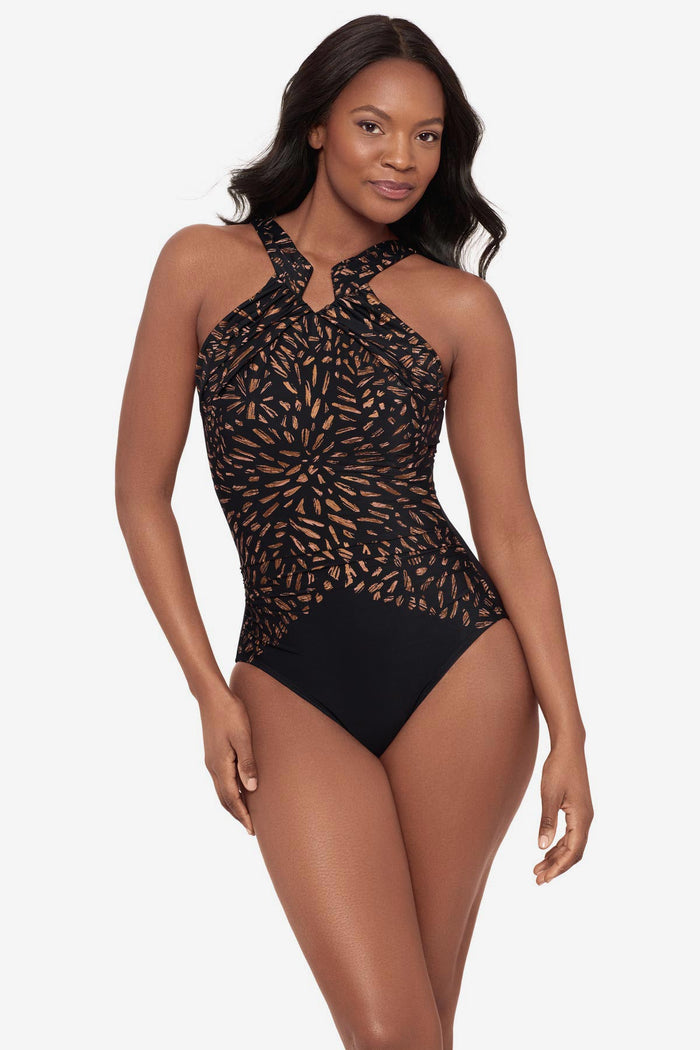 Woman wearing a black and brown printed one-piece swimsuit with a high neckline