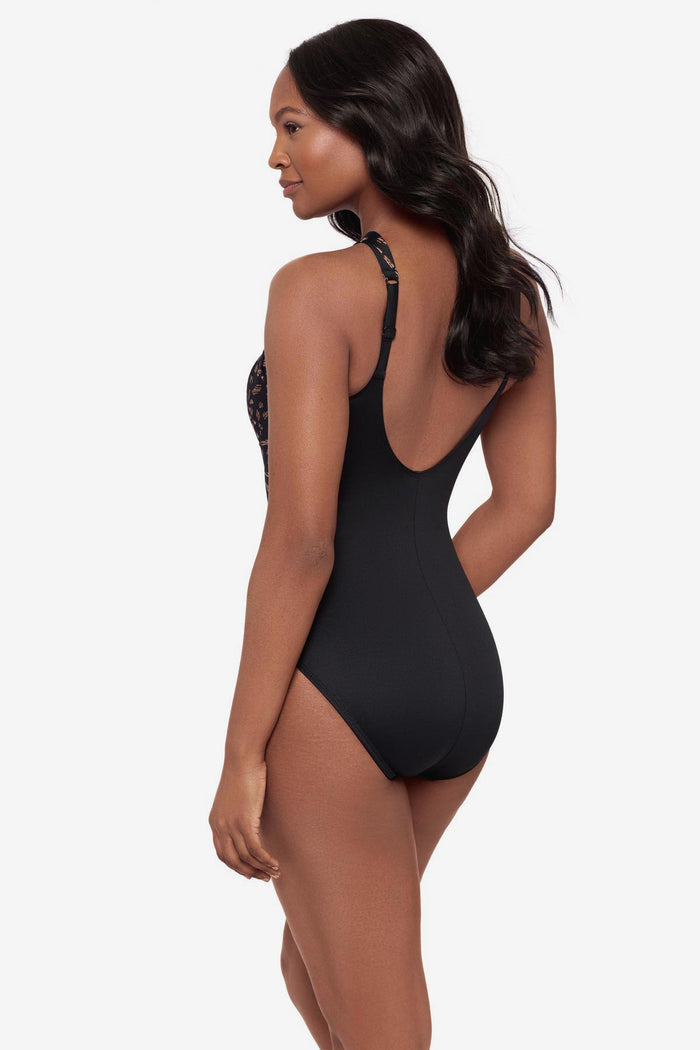 Woman turned left wearing a black and brown printed one-piece swimsuit