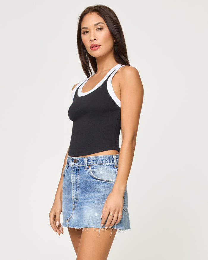 Side view of a model wearing the LSPACE Ash Tank in black white, showing the ribbed texture and contrast-trim straps.
