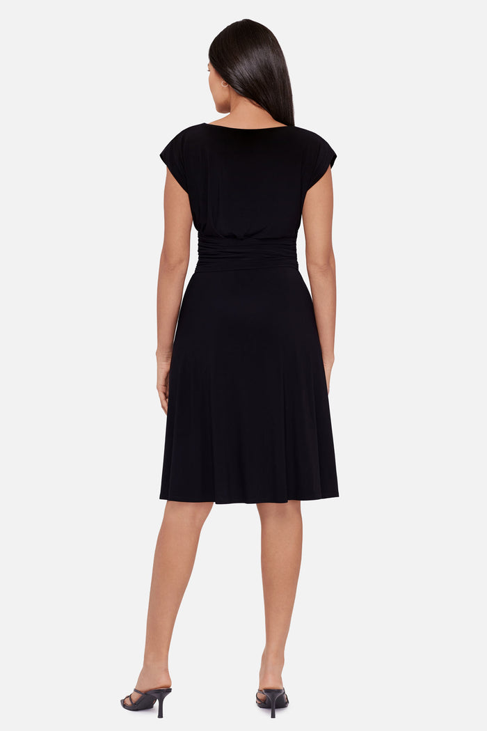 Woman faced away wearing a black short sleeve mid length dress