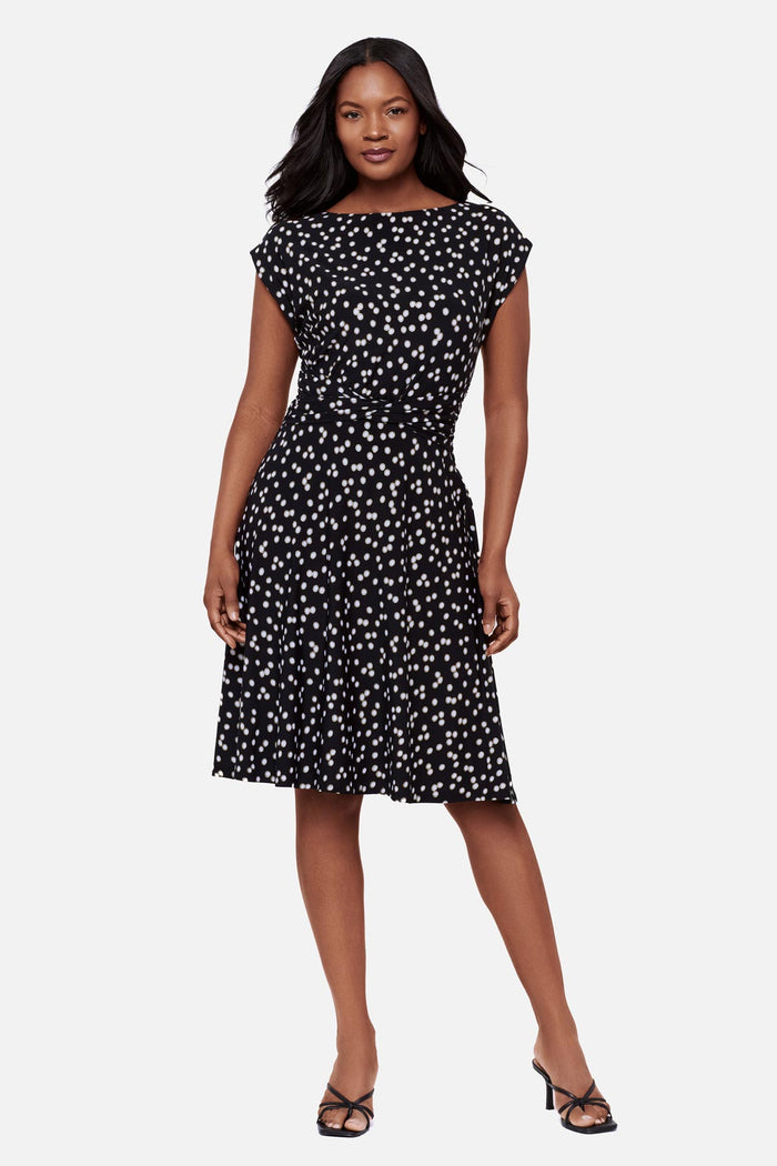 Woman wearing a black and white polka dot short sleeve mid length dress