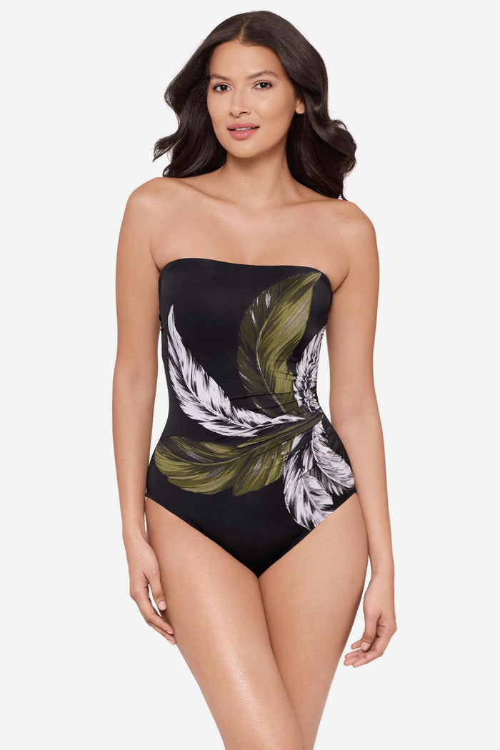 Woman wearing a strapless green and white feather printed one-piece swimsuit