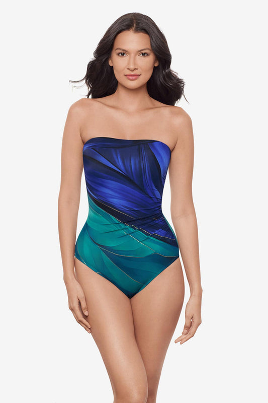 Woman wearing a multi-blue bandeau one-piece swimsuit with gold detail