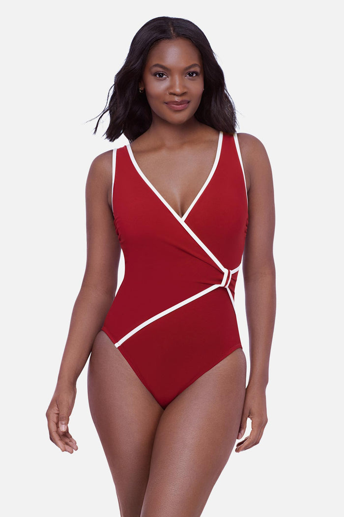 Woman wearing a cherry red one-piece swimsuit with white piping on the edges