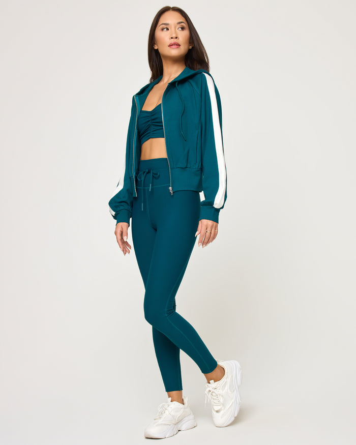 Side view of model wearing the Back To Back Jacket in deep teal-cream with matching deep teal-cream Back To Back Pant.