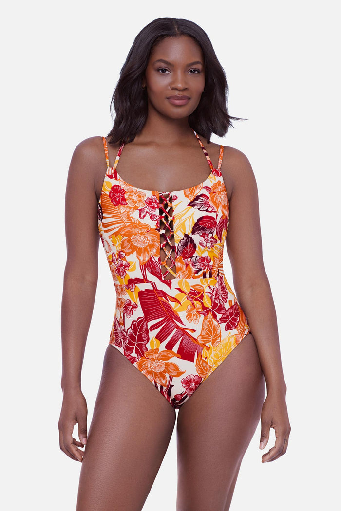 Woman wearing a multicolored palm leaf printed one-piece swimsuit with lattice down the front