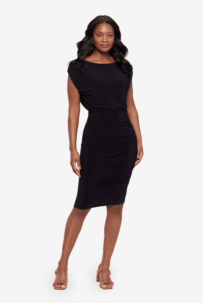 Woman faced forward wearing a tunic black dress