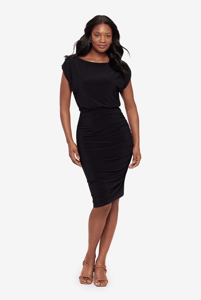 Woman faced forward wearing a tunic black dress