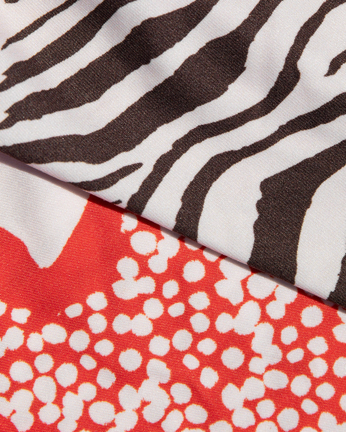 Close-up of black and white animal print and red hibiscus bloom print fabric used in the LSPACE Animal Hibiscus Bloom Banning Bikini Bottom.