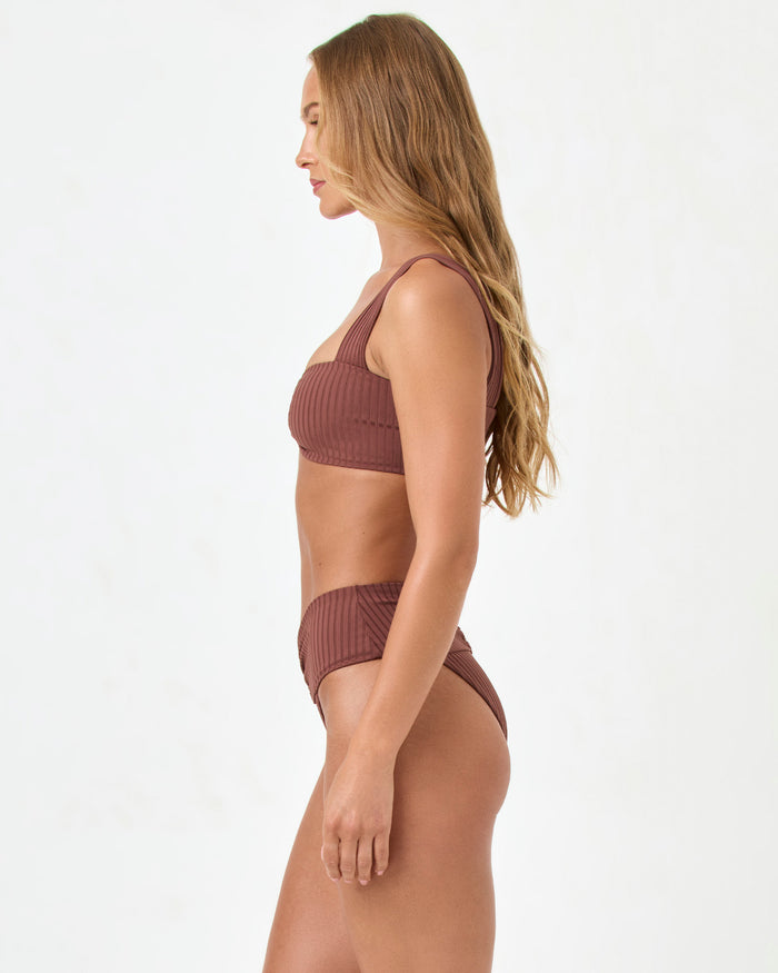 Side view of a model wearing the LSPACE cafe Bardot Bikini Bottom with a matching ribbed Marlee Bikini Top.