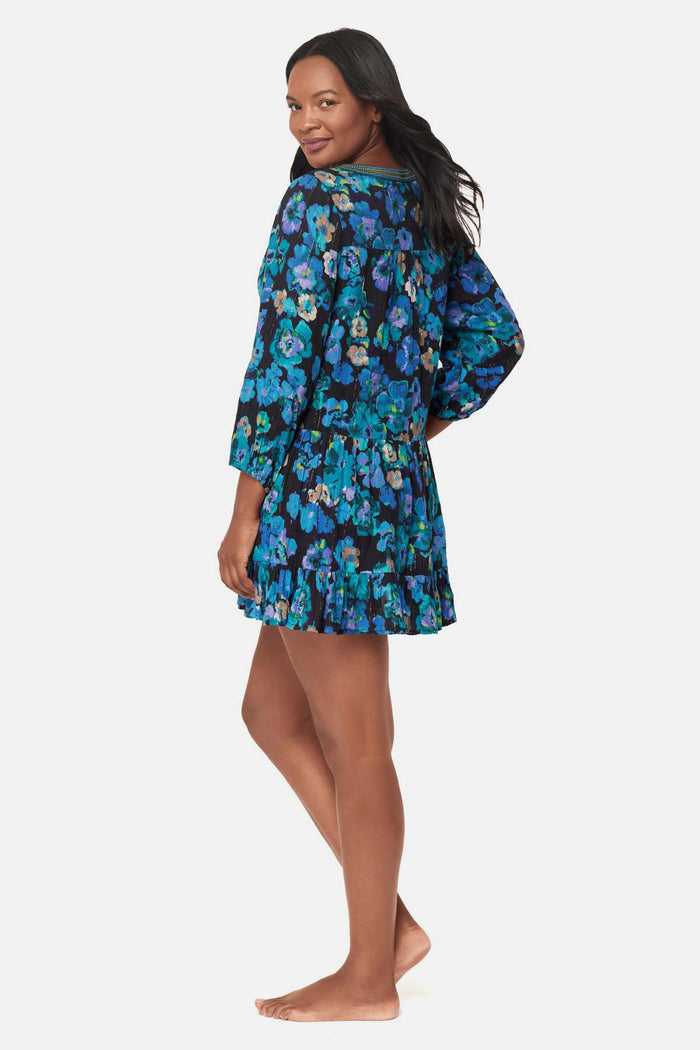 Woman turned left wearing a black and blue floral printed swim cover up dress