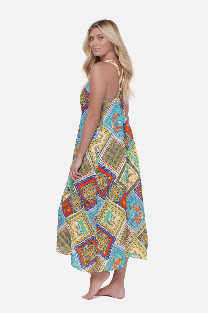 Woman turned left wearing a printed swim cover up with detailed artwork in each tile