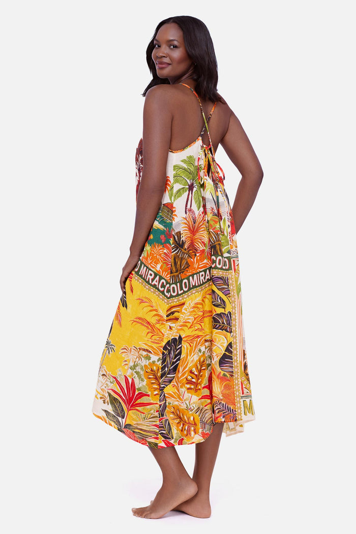 Woman turned left wearing a multicolored tropical scene printed swim cover up