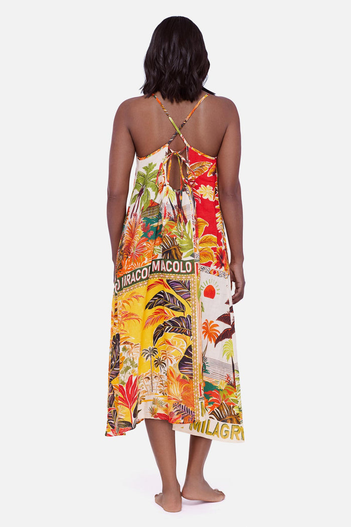 Woman turned away wearing a multicolored tropical scene printed swim cover up