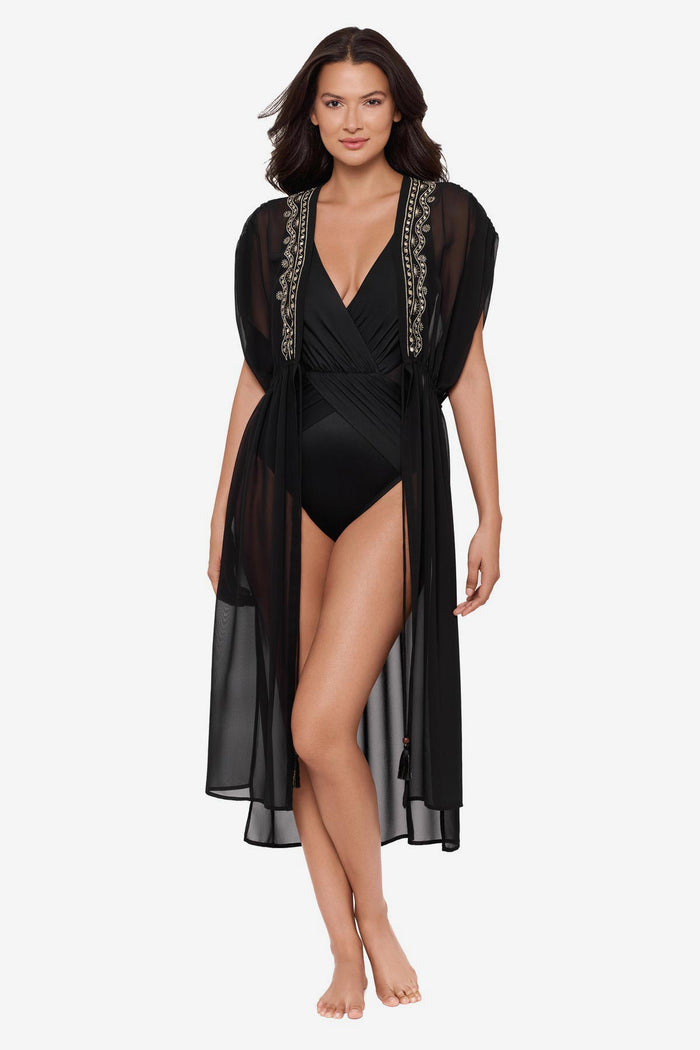 Woman wearing a black kimono swim cover up with embellishments along the opening