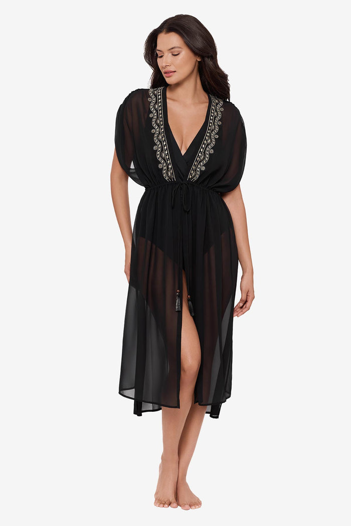 Woman wearing a black kimono swim cover up with embellishments along the opening