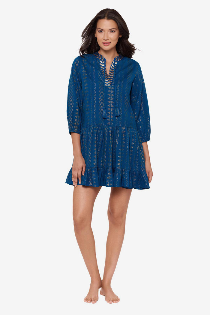 Woman wearing a blue pull-over kimono swim dress with gold detailing on the front