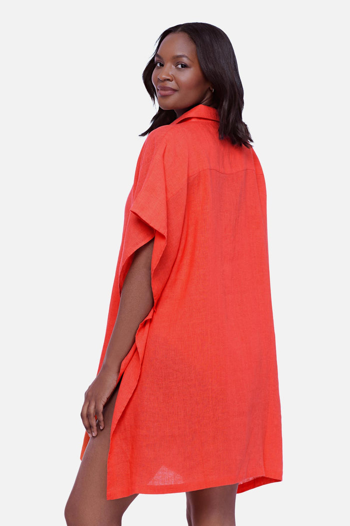 Woman faced left wearing an orange oversized swim cover up shirt