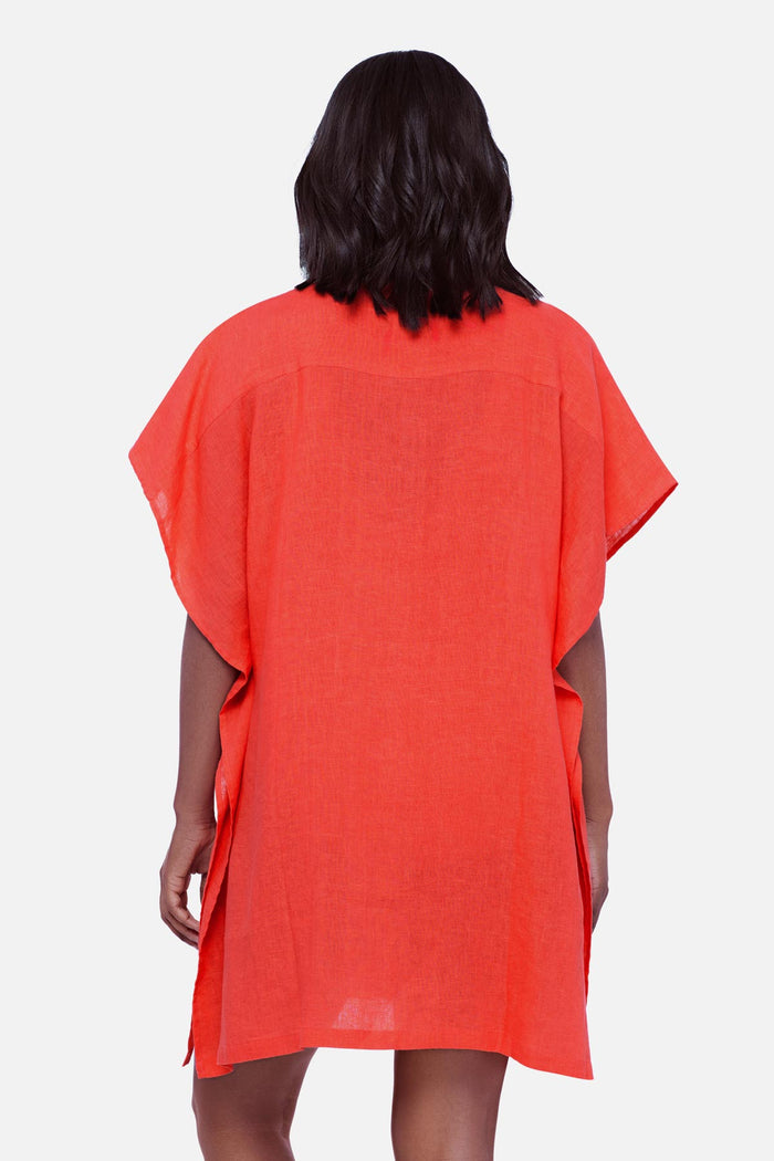 Woman faced away wearing an orange oversized swim cover up shirt