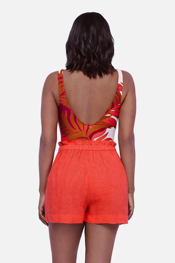 Woman turned away wearing an orange swim short cover up