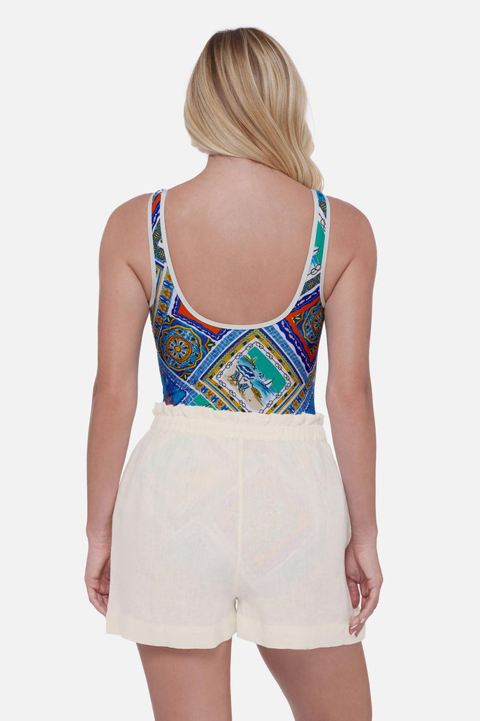 Woman turned away wearing ivory colored swim cover up shorts