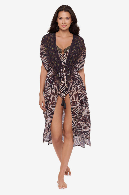 Woman wearing a brown printed kimono swim cover up with a matching swimsuit underneath