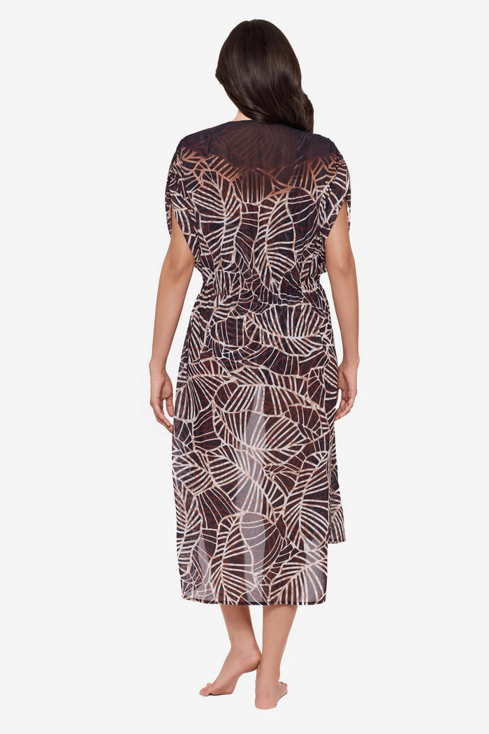 Woman turned away wearing a brown printed kimono swim cover up