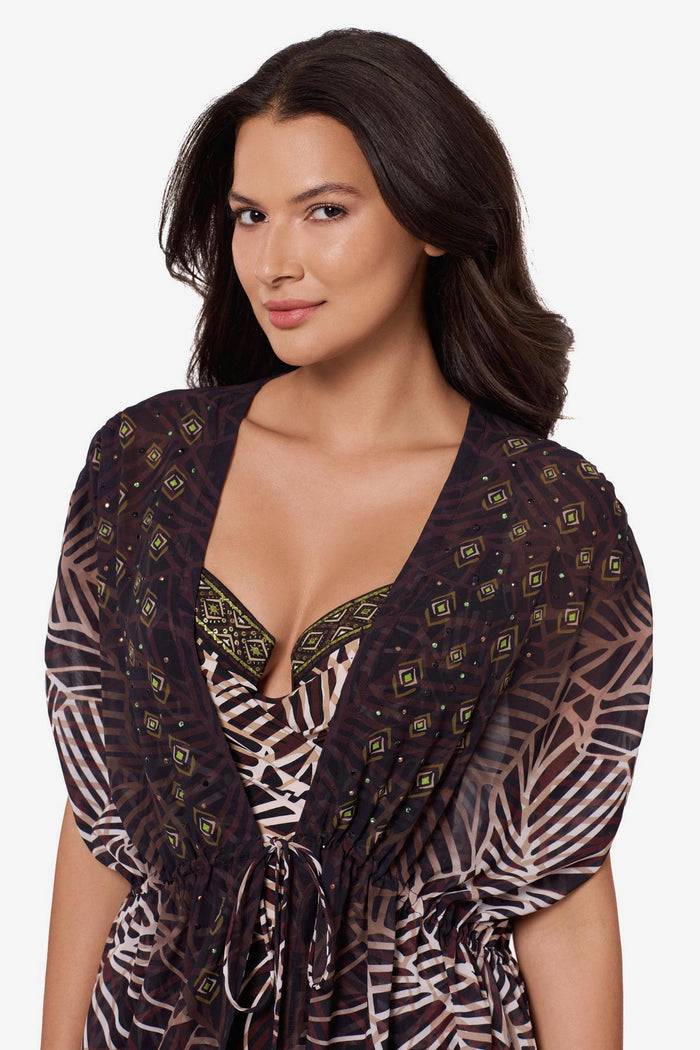 Close up of woman wearing a brown printed kimono swim cover up with a matching swimsuit underneath
