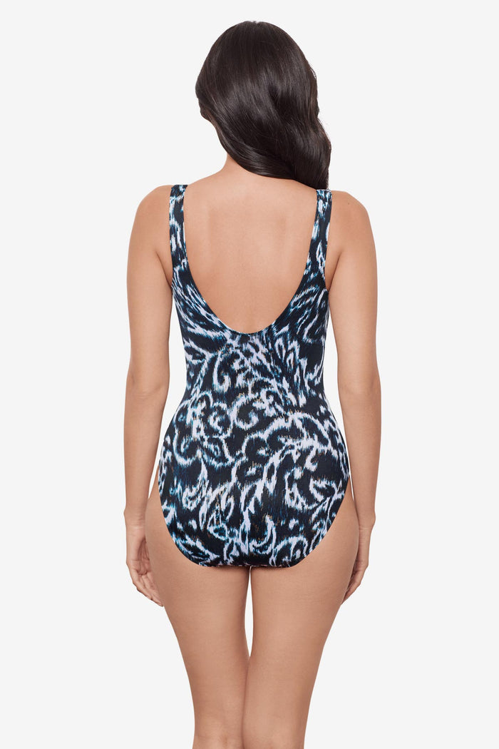 Woman turned away wearing a black and white abstract printed V neck one-piece swimsuit