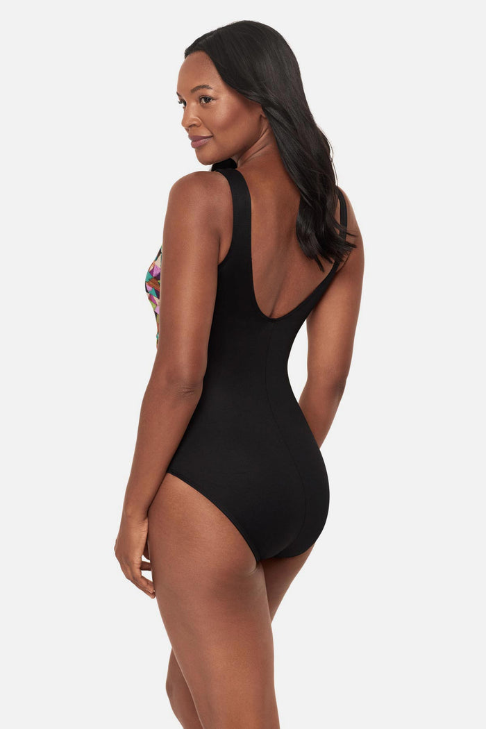 Woman turned left wearing a multicolored geometric high neck one-piece swimsuit