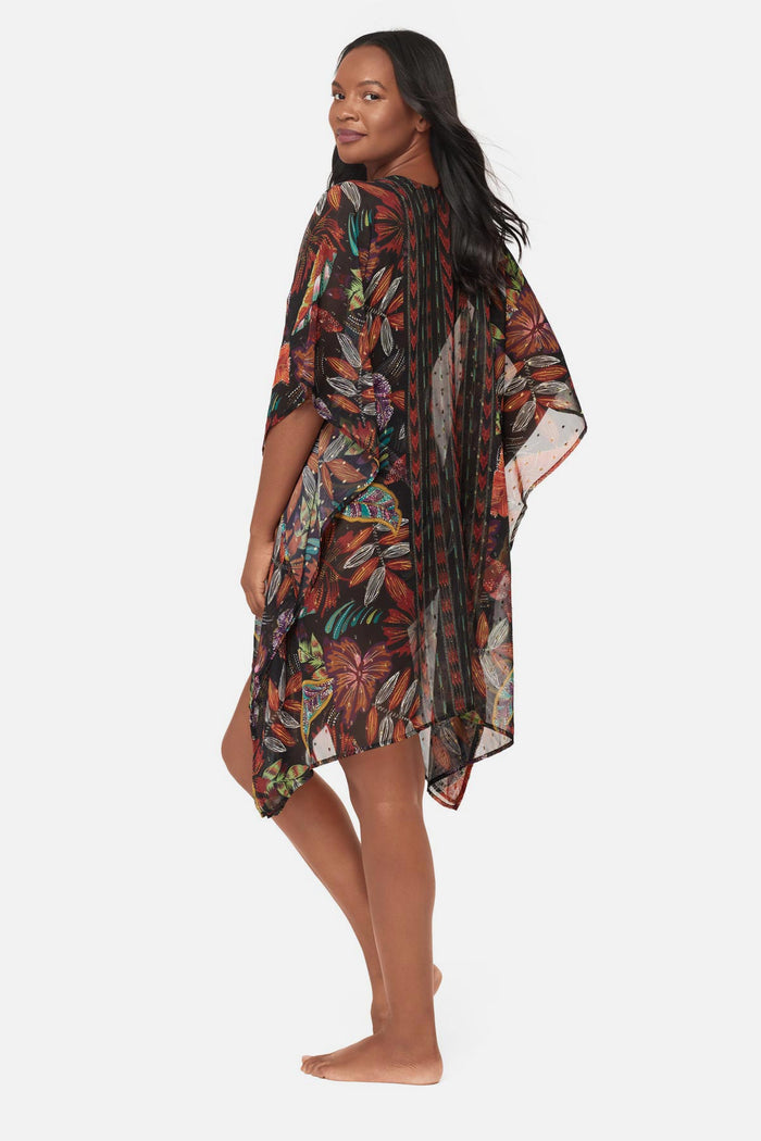 Woman turned left wearing a multicolored floral printed caftan swim cover up