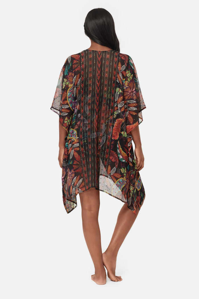 Woman turned away wearing a multicolored floral printed caftan swim cover up